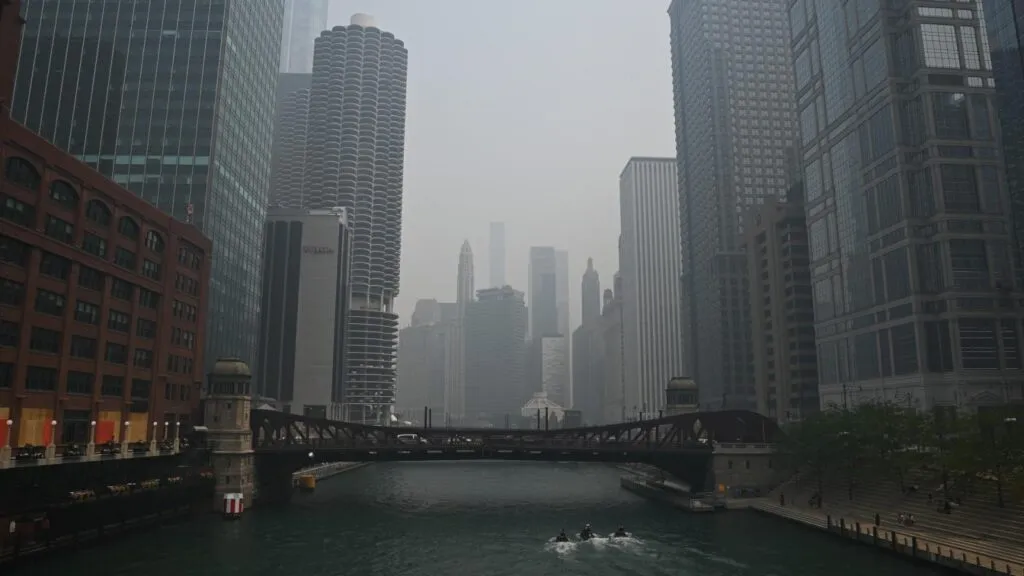 De skyline en rivier van Chicago herleid tot grijze silhouetten door dichte bosbrandrook.