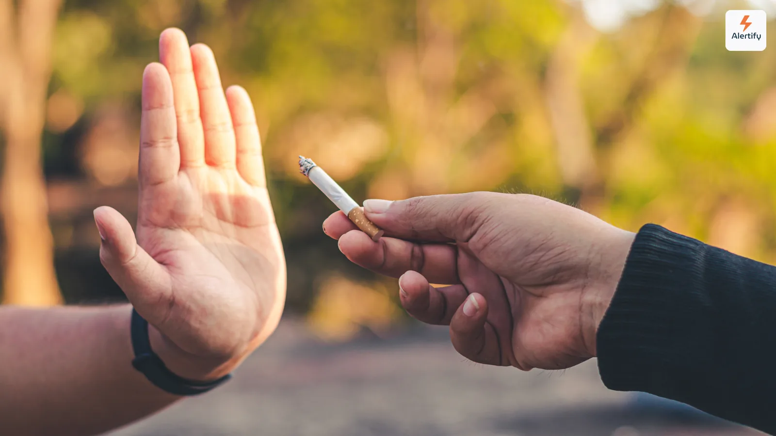 Hand die beleefd een aangestoken sigaret weigert die door iemand anders buiten wordt aangeboden